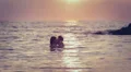 Lovers kissing in the sea at sunset - love - man and woman kiss HD Footage