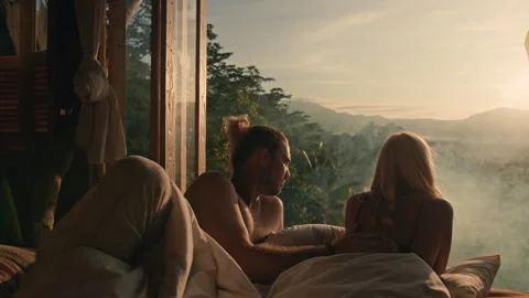 Lovers lying in bed with an amazing view and drinking tea Stock Footage 269476561