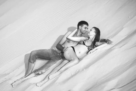 Lovers lying on sand Stock Photos