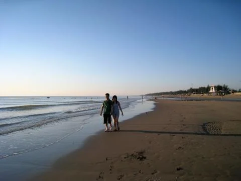 Lovers stroll on the beach Stock Photos