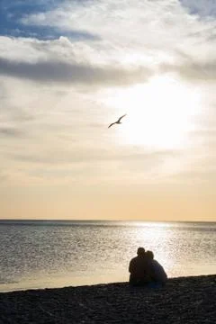 Lovers at sunset on the beach Stock Photos