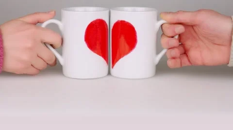 Lovers taking a coffee cups with halves of the heart and put they together. Stock Footage 59532175