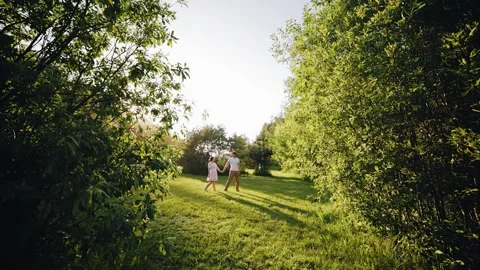 Lovers walk at sunset holding hands Stock Footage 250484767