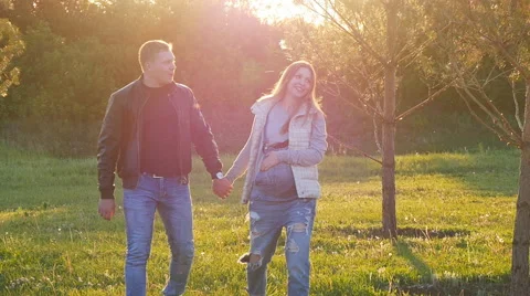 Lovers walking in a field at sunset Stock Footage 64494661