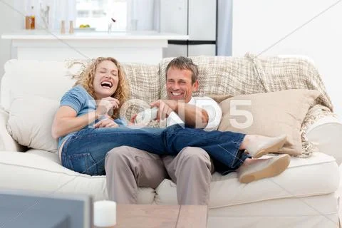 Lovers watching tv in the living room at home Stock Photos