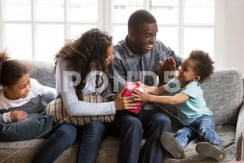 Loving african family sitting on couch at home Stock Photos