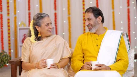 Loving aged couple talking while sipping hot tea - South Indian couple, decor... Stock Photos