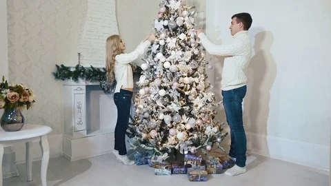 Loving beautiful couple standing dresses a Christmas tree Video stock 75241908