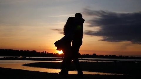 A loving couple on a date by the river with a sunset, a man circling a woman in Stock Footage 80858879