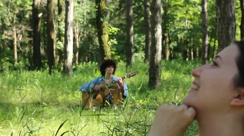 Loving couple in the forest and a guy with guitar Vídeo Stock 32847819