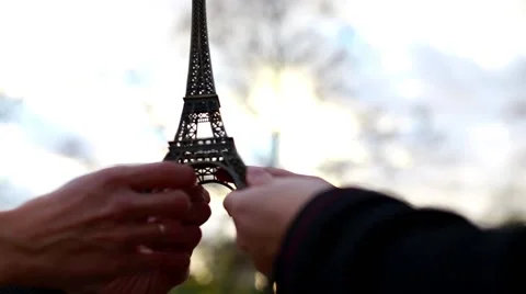 A loving couple holding model of Eiffel Tower at sunset Video stock 56377673