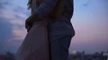 Loving couple hugging each other and whispering tenderness on roof at dusk 4k or 4k+ Resolution