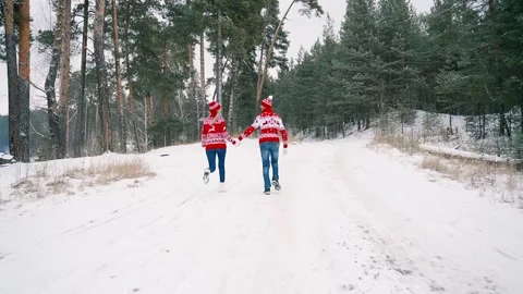 A loving couple runs through the winter forest holding hands. Stock Footage 149696983