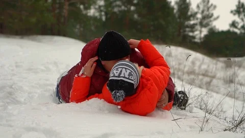 A loving couple slides down from a snow hill Stock Footage 88921675