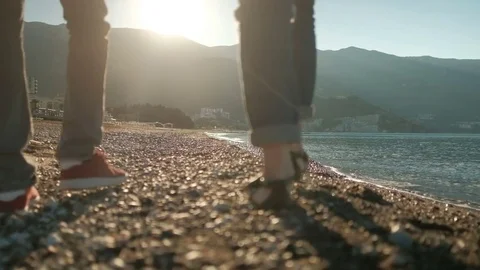 Loving couple strolling along stony beach on sunny day. Stock-Footage 77652017