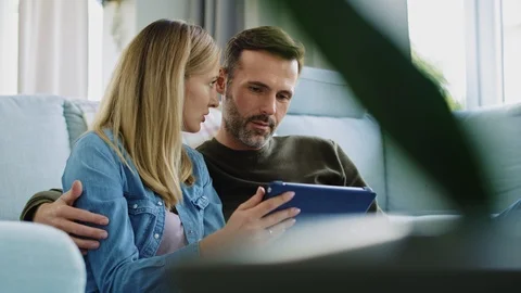 Loving couple using a tablet in living room Stock-Footage 117466054