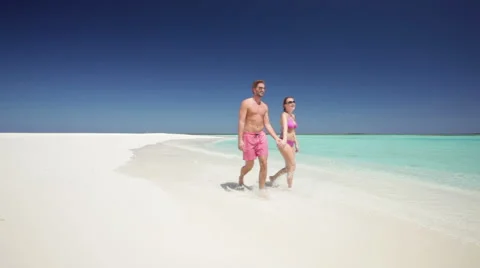 Loving couple walking towards camera on sandy beach Stock Footage 1018200