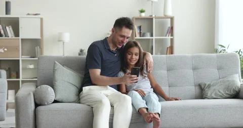 Loving dad teach, explain, show to daughter new mobile app Stock Footage 237329642