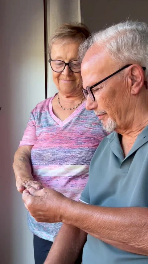 Loving elderly couple celebrating their anniversary as the husband gently Stock Footage 344250409