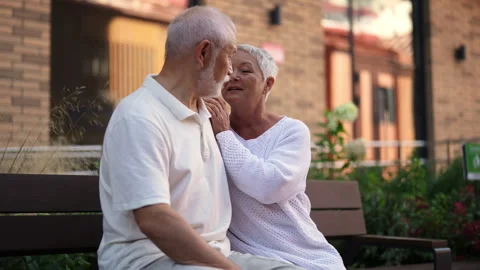 Loving elderly couple with gray-haired enjoying each other company sitting on Stock Footage 287343282