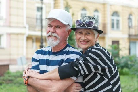 Loving elderly couple posing on camera. Pensioners hug each other. Happy old  Stock Photos