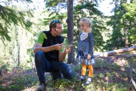 Loving father explaining things about plants to his little daughter in the mo Stock Photos