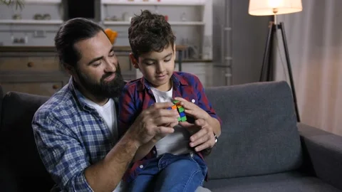 Loving father teaching son to solve puzzle cube Stock-Footage 100719141