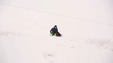 Loving guy and girl skate in the winter with a snowy mountain on snowtube Stock Footage