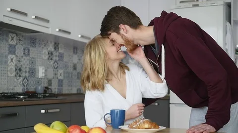 Loving guy hugging his smiling girlfriend in their kitchen early in the morning Stock Footage 74514010