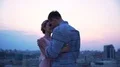 Loving guy turning his beautiful lady in dance on the open terrace, cityscape 4k or 4k+ Resolution