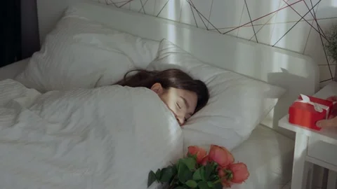 Loving man hand putting presents while young female woman sleeping, holiday Stock Footage 169973395