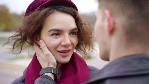 Loving man is touching face of his girlfriend and talking with her, woman is Stock Footage 98809253