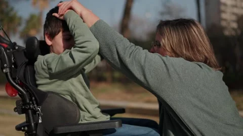 Loving mother caring for disabled son in wheelchair Stock-Footage 302792694