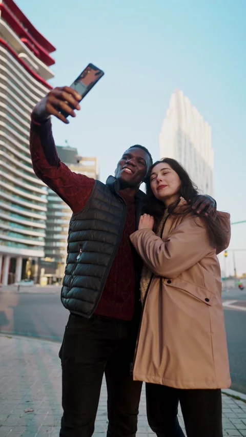 Loving multiracial couple taking self portrait in city Stock Footage 169403108