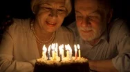Loving Senior Couple Celebrating Anniversary With Cake At Home In The Evening Stock Footage