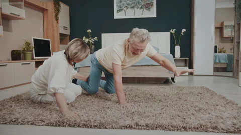 Loving senior couple supporting each other during home yoga session. Видео 327538556