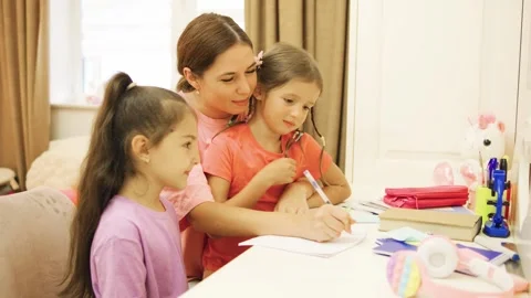 The loving single mother happily does homework with her two daughters at home Stock Footage 281128868