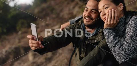 Loving young couple on hike taking a selfie Stock Photos