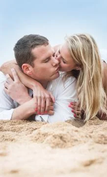 Loving young couple sitting lying on beach Stock Photos