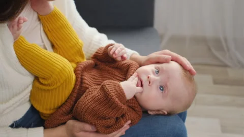 Loving young mother sitting on couch together with little infant child son Stock Footage 253997720