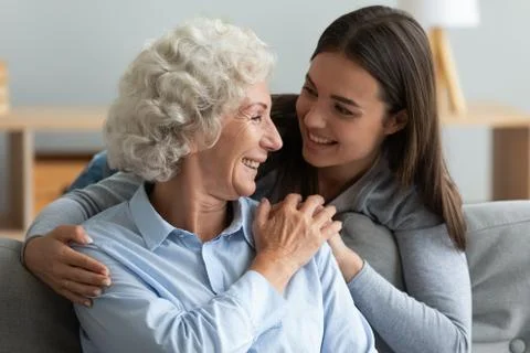 Loving young woman granddaughter hugging senior grandma giving care Stock Photos
