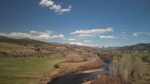 Low aerial above Eagle River and cow pastures near Vail Colorado in spring Stock Footage 274085694