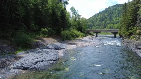 Low Aerial Drone Flight Along Assemetquagan River With Bridge and Traffic Ahead Video stock 342834216