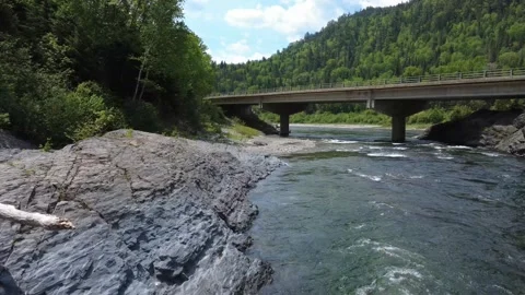Low Aerial Drone Flight Along Assemetquagan River With Bridge and Traffic Ahead Video stock 342843439