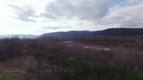 Low aerial drone flight over shallow mountain river in natural wilderness Stock Footage 326941144
