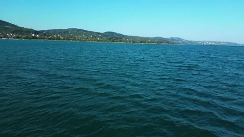 Low Aerial Flight Over Calm Blue Coastal Water Stock Footage 342345427