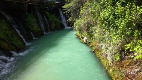 Low Aerial Flight Over Lush Stream Surrounded by Cascading Waterfalls Stock Footage 340151261