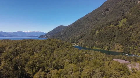 Low Aerial Flight Over Treetops Towards Turquoise River and Lake in Chile Video stock 325820154