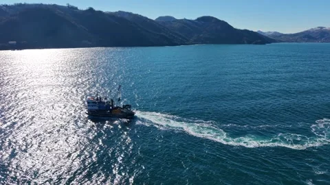 Low Aerial Flight Passing Close to Fishing Boat Near the Coast Stock Footage 343396413