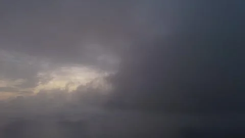 Low aerial flight through dense clouds at dawn showing sunlight casting ora.. Stock Footage 317532530